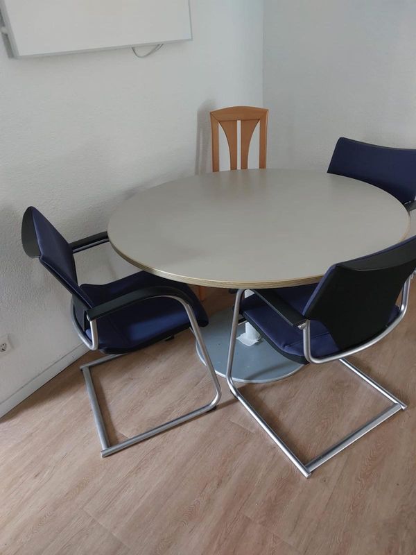 Runder Tisch mit gepolsterten Stühlen im Zimmer