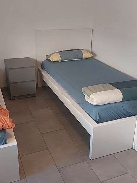 Zimmer mit Bett und Nachttisch