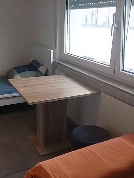 Zimmer mit Tisch am Fenster und Bett