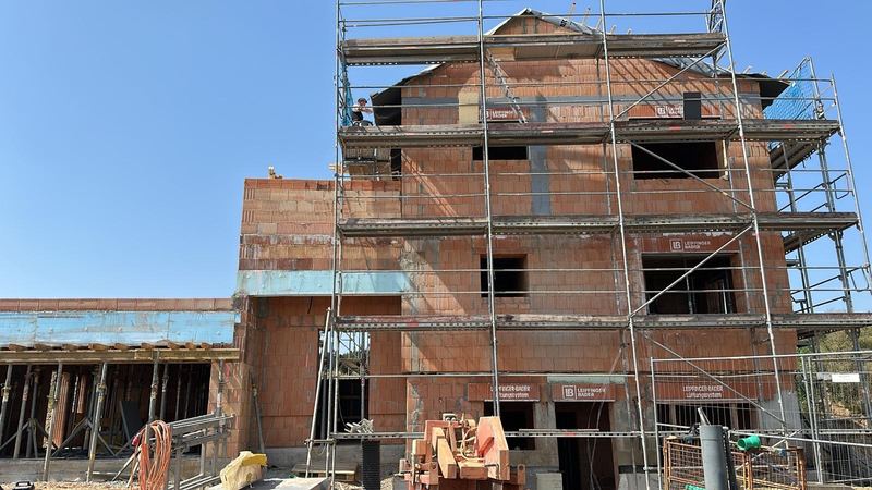 Mauerwerk mit Deckenschalung und Gerüst bei klarem Himmel
